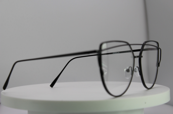 Black eyeglasses on a white platform with a gray background