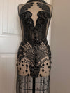 Black beaded dress on a mannequin against a neutral background