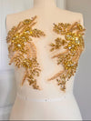 Mannequin wearing a backless dress with gold floral embellishments.