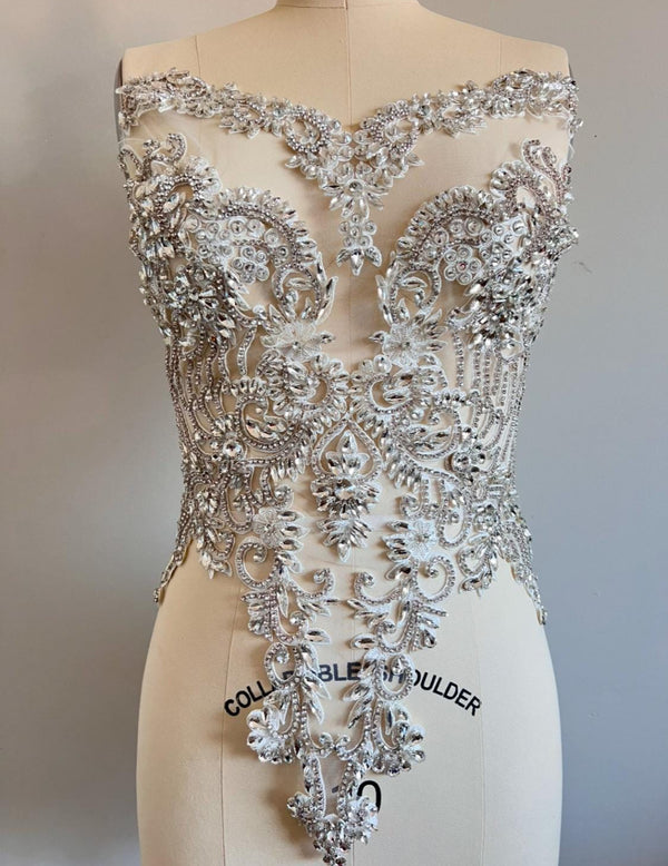 Silver beaded top on a mannequin with a plain background