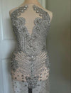 Elegant dress with intricate silver beadwork on a plain background