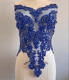 Blue beaded top on a mannequin against a plain background