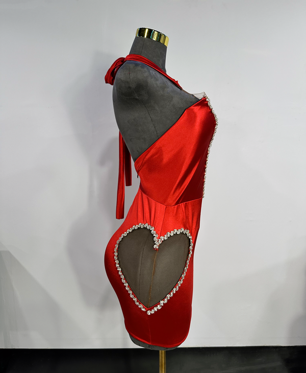 side view of red halter dress with heart side cutout trimmed in silver rhinestones by Bellz Couture Detroit on a mannequin against a plain wall
