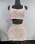 A two-piece outfit with a sequined tank top and a matching mini skirt, both adorned with pink ribbon bows and rhinestone accents by Bellz Couture of Detroitdisplayed on a mannequin.